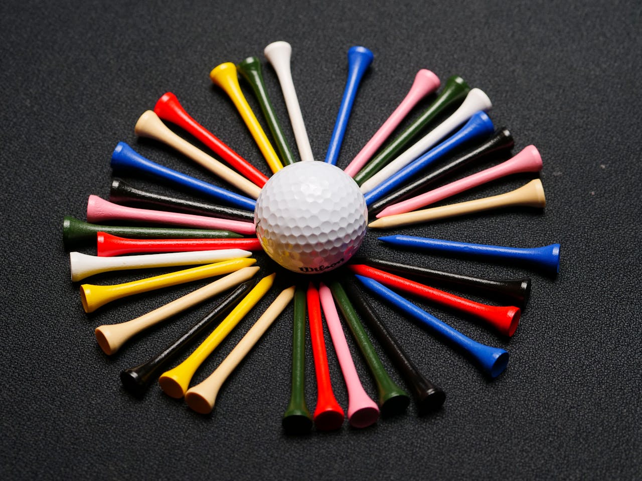 Vibrant golf tees form a circle around a golf ball, showcasing sporty elegance.